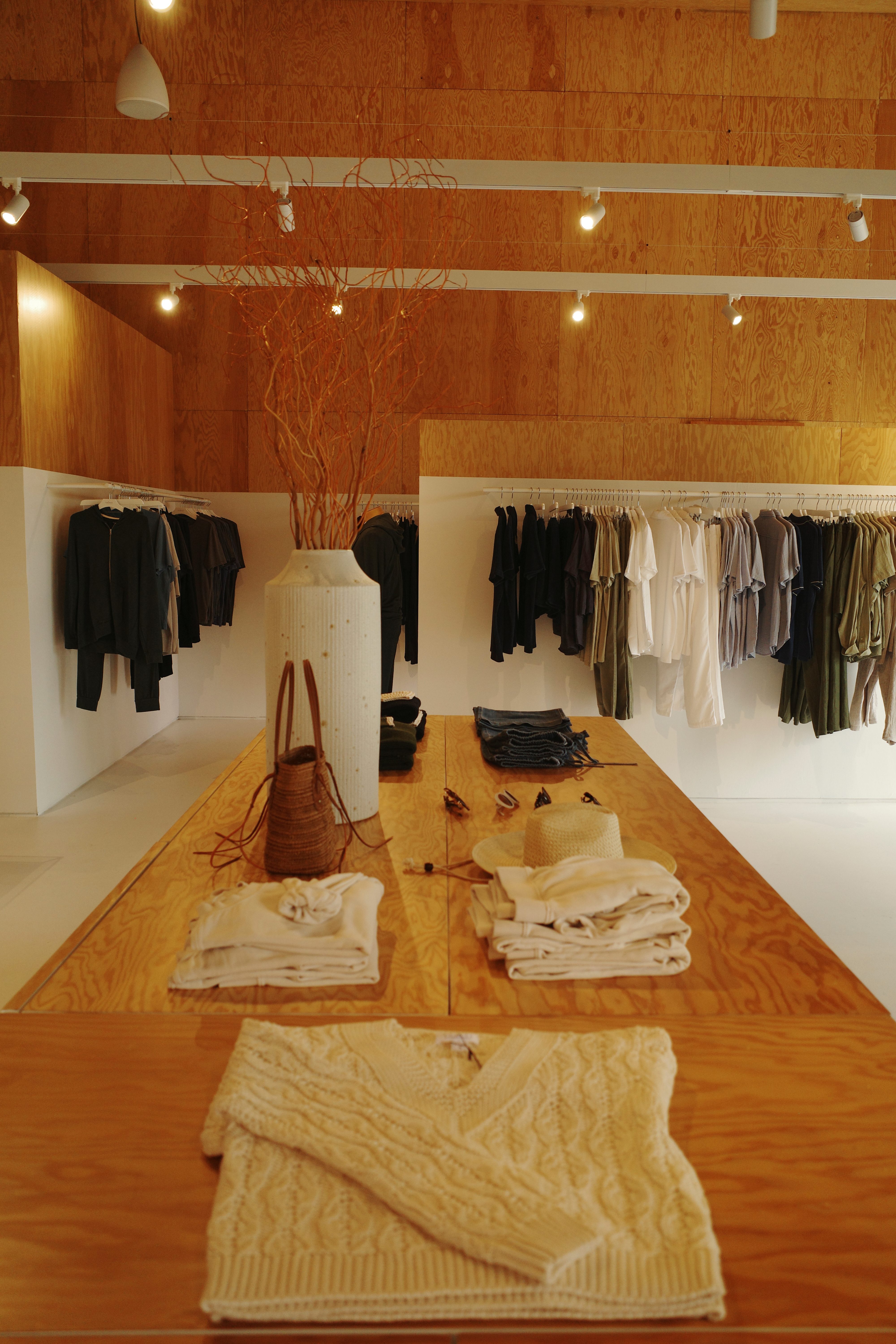 Clothing store interior at Cross Creek Ranch, racks and table display of apparel and accessories.
